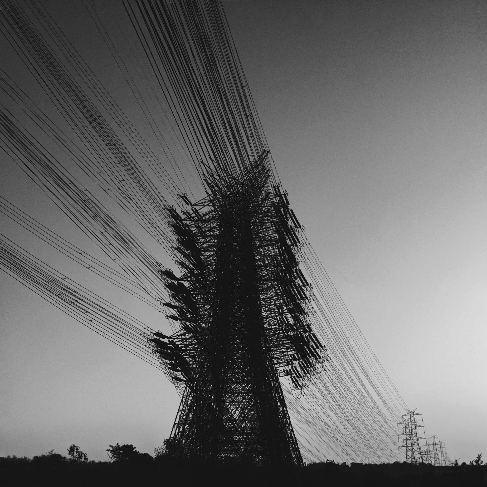 pexels-photo-7299506-7299506 Artistic black and white photo of a power transmission pylon with wires.